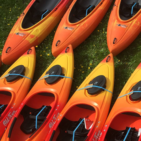 Kayaks laid out on the grass.